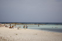 Tourists swimming and sun bathing on popular Baby Beach.