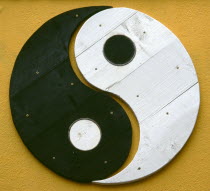 Yin and Yang symbol painted onto a wall. Yin Yang originates in ancient Chinese philosophy and metaphysics  which describes two primal opposing but complementary forces found in all things in the univ...