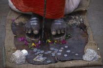 Cropped shot of sadu standing on nail shoes with coins given by passers-by.