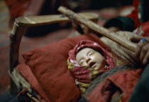 Kirghiz baby asleep in cot.
