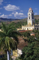 Iglesia San Franciso de Paula roof and bell tower with red tiled rooftops and palm tree in the foreground.church