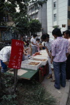 Young women at street stall selling moon cakes for Moon Festival.
