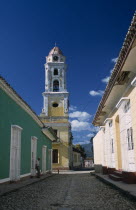View along street of colourful colonial architecture toward church bell tower Colorful