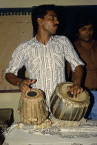 Young man playing tabla drums.