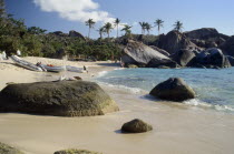 The Baths.  Quiet sandy beach with large boulders along shoreline.