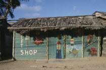 Green thatched roadside shop with naive paintings on it