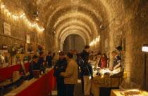 Indoor Wine Festival with people tasting at stalls.