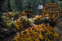 Graves in Tzurumutaro Cemetary decorated with flowers fruit and candles for Day of the Dead celebrations.