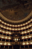 Teatro San Carlo opera house interior with painted ceiling and ornate balcony boxes.
