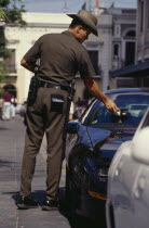 Traffic policeman issuing parking ticket.