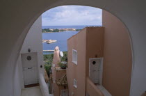 Italy, Sardinia, Costa Smeralda, Porto Cervo brightly painted apartment alley way looking out over the harbour.