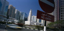 City centre mosque surrounded by modern high rise buildings with speeding traffic and no entry sign in the foreground.Center United Arab Emirates