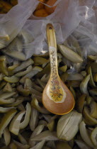 Spoon in a bowl of green mangoes with vinegar on a stall at the Night Market in Cenang