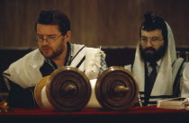 Two Rabbis saying Mincka prayers in front of Torah scrolls inside Catford Synagogue