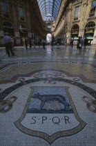 Galleria Vittorio Emanuele II shopping arcade interior with glass domed roof and mosaic floor lined with designer shops.