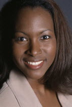 Indoor head and shoulders portrait of a young woman smiling