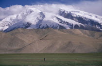 Snow capped mountains near the Pakistan border with man standing in the distance
