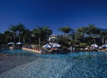 Seaworld. View across a pool towards visitors gathered along the edge near sun shades