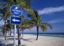 Storm Evacuation Sign on sandy beach near palm trees