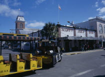 Duval Street. Sloppy Joes Bar and Tourist Train traveling along road