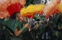 Notting Hill Carnival dancers wearing flower costumes and playing hand held steel percussion instruments