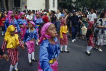Notting Hill Carnival. Children in costume blowing whistles during parade.