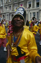 Notting Hill Carnival man dressed as a pirate with yellow shirt and skull and crossbones hat