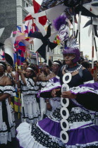 Notting Hill Carnival dancers in black  white and purple costumes