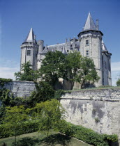 Looking over the garden with high walls up to the chateau with turrets.