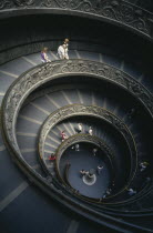 The spiral staircase in the Vatican Museum with tourists descending the stairs