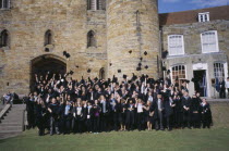 Graduate wearing their mortar boards and gowns  posing for a group photo. Some motar board having been thrown in the air.Tonbridge Kent