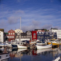 Boats moored in harbour with colourful waterfront buildings behind.Capitol Colorful