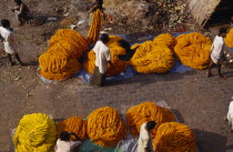 Looking down on marigold sellers.  Marigolds are sold by weight or in garlands and are used for weddings  funerals  puja and decoration.  Kolkata