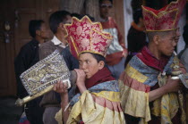 Young Tibetan Buddhist lamas playing the Shankh or conch shell.