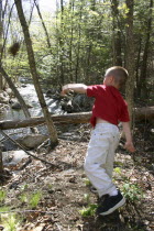 Tyler Stone throwing rocks into brook.  New Hampshire boy playing   stream