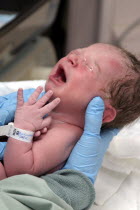 Kylan Stone  newborn baby girl crying  being checked by nurse in hospital.