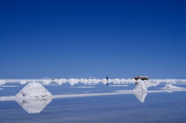 Salt flats with salt piled up ready to be collected by truck. Lorry