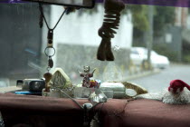 Dashboard of Caracas taxi including religious artefacts  a comb and reading glasses.