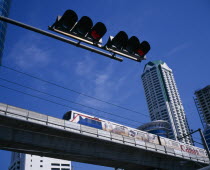 Looking up at skytrain  traffic lights and high rise commercial building.