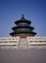 Temple of Heaven.  Hall of Prayer for Good Harvests with western tourist standing at top of steps to entrance.Peking Beijing