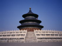 Temple of Heaven.  Hall of Prayer for Good Harvests with western tourist standing at top of steps to entrance.Peking Beijing