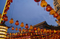 Temple roof decorated with lights and hung with red and yellow Chinese lanterns at Chinese New Year.