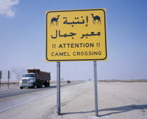 Camel Crossing road sign on Eastern Highway to Dammam with passing truck behind.Lorry