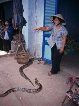 Woman with pythons in market.