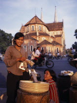 Female street hawkers selling snacks in front of Notre Dame Cathedral.