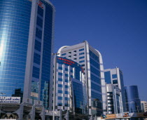 Dubai Concorde Hotel and Residence on Al Maktoum Road.  Modern glass fronted exterior of hotel beside offices or apartments to let and advertising hoarding.Dubayy United Arab Emirates