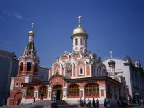 Exterior of refurbished church with red and white painted facade  gold domed roof and painted icons above the entrance.Eastern Europe