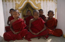 Young novice monks meditating in front of shrine near Mandalay.Burma Myanmar