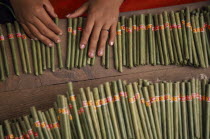 Cropped shot looking down on hands of female worker in cheroot factory workplace.Burma Pegu Bago Myanmar