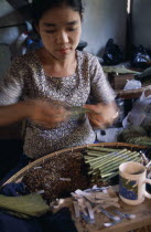 Young female worker rolling cheroots by hand inside factory workplace.Burma Pegu Bago Myanmar